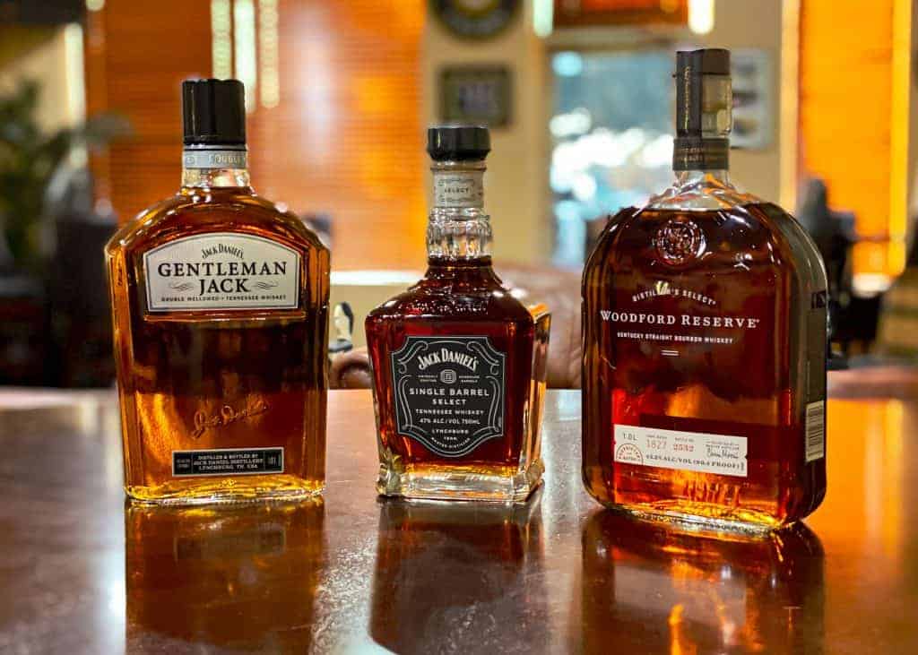 Bourbon Bottle Etching Event Photo - Shows 3 bottles of bourbon. Gentleman Jack, Jack Daniels Single Barrel, and Woodford Reserve